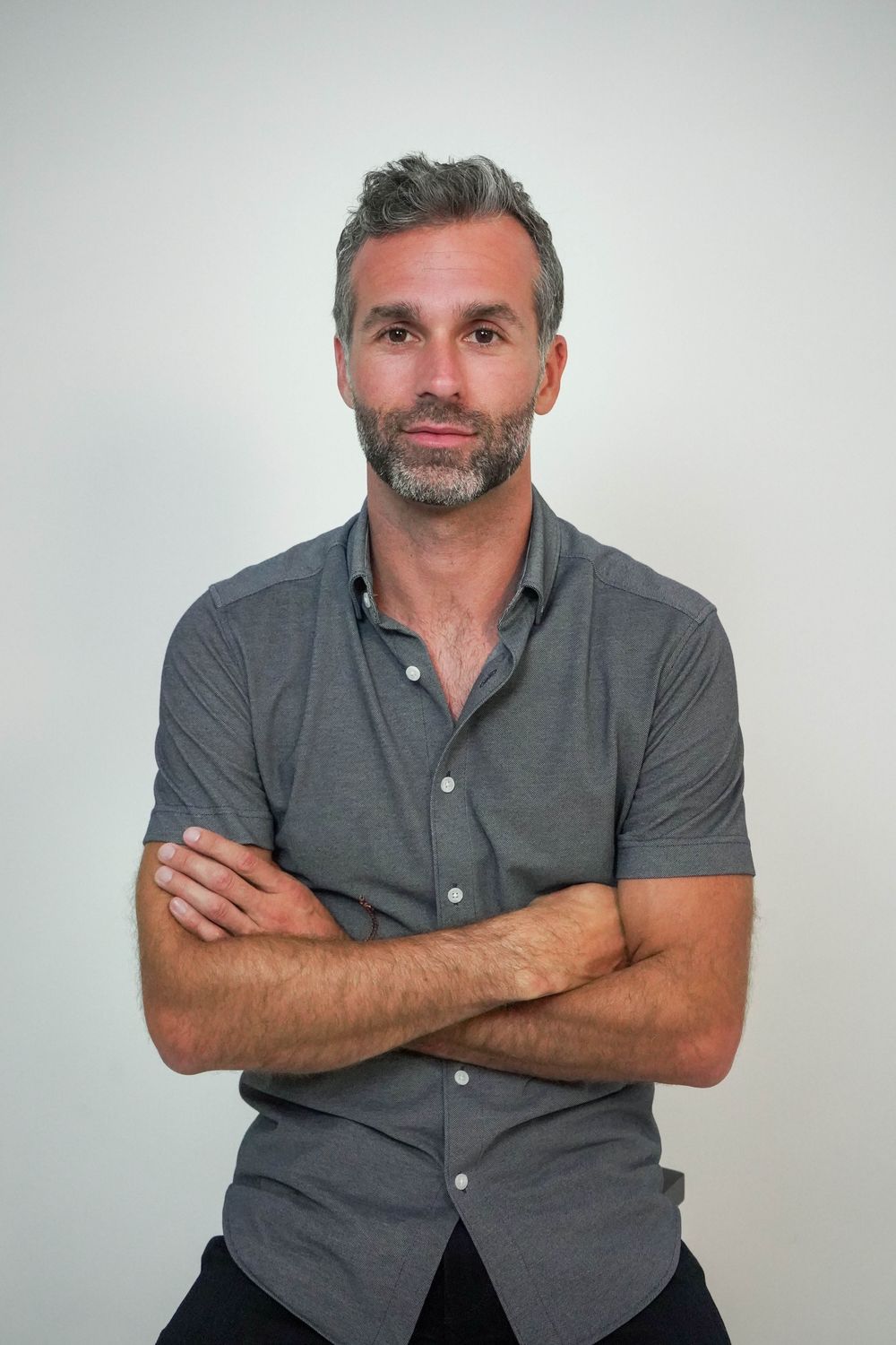 Mike Moll, arms crossed, in a grey shirt