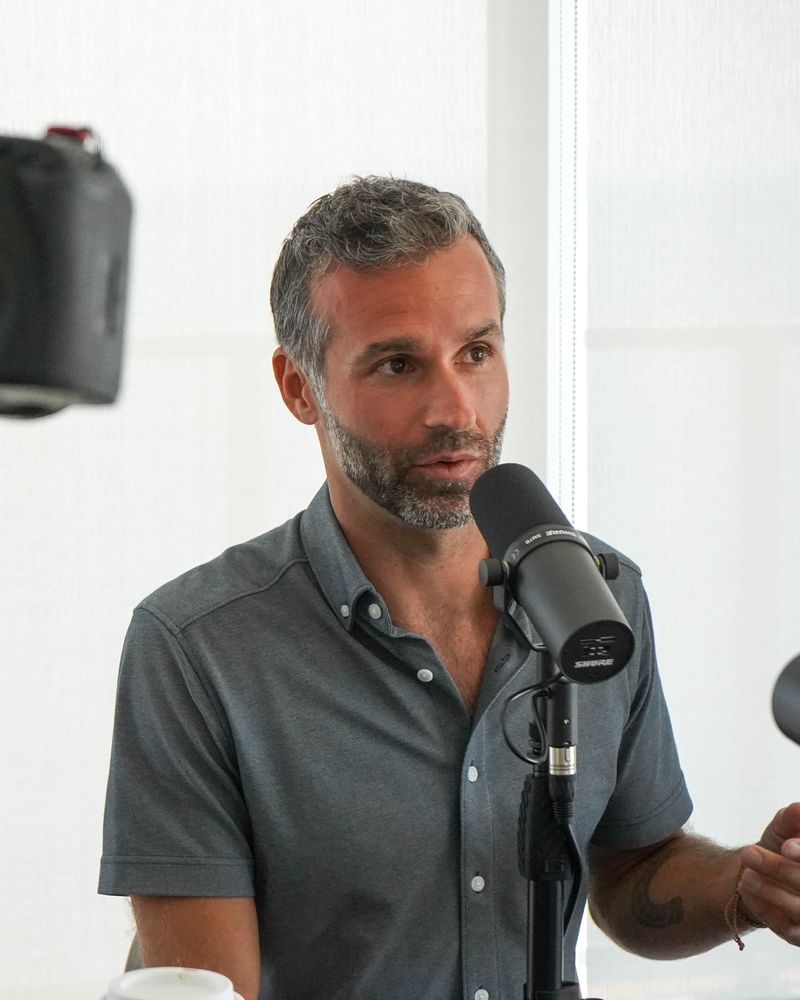 Mike Moll talking into a podcast microphone during an interview